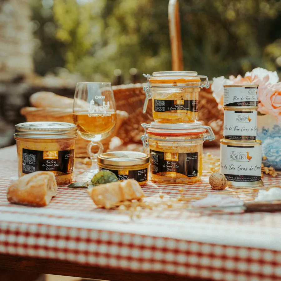 Bocaux de terrines et de foie gras sur une table en plein air