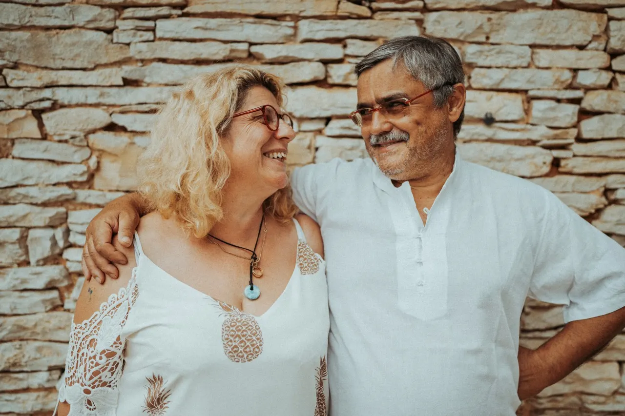 Marie-Pierre et Yves Robert, souriants, devant le mur en pierre de la ferme